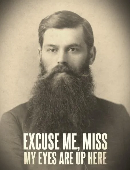 Vintage portrait of bearded man with 'my eyes are up here' caption