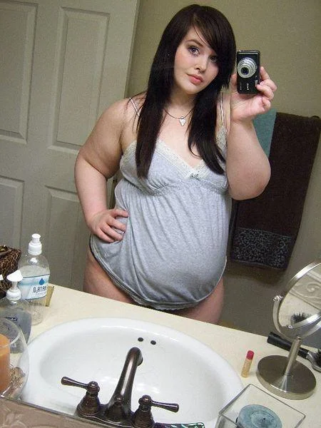 MySpace Angles — Bathroom mirror selfie of a woman using a digital camera at a high angle