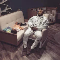 Napping Kanye — Kanye West sleeps on display furniture in light-colored clothing while his young daughter North West naps on a nearby couch.