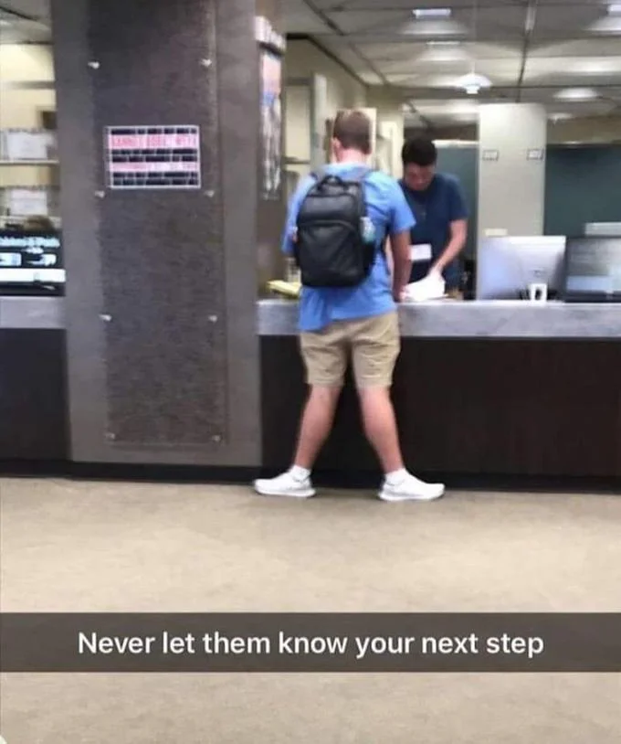 Never Let Them Know Your Next Move — Man at service counter viewed from behind with caption 'Never let them know your next step'