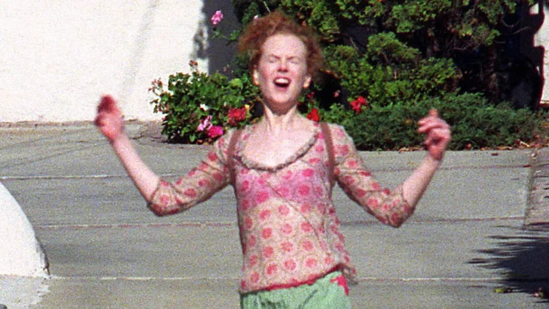 Nicole Kidmans Divorce Photos — A clean paparazzi photograph of Nicole Kidman with arms spread wide and mouth open in joy, wearing pink floral shirt and green