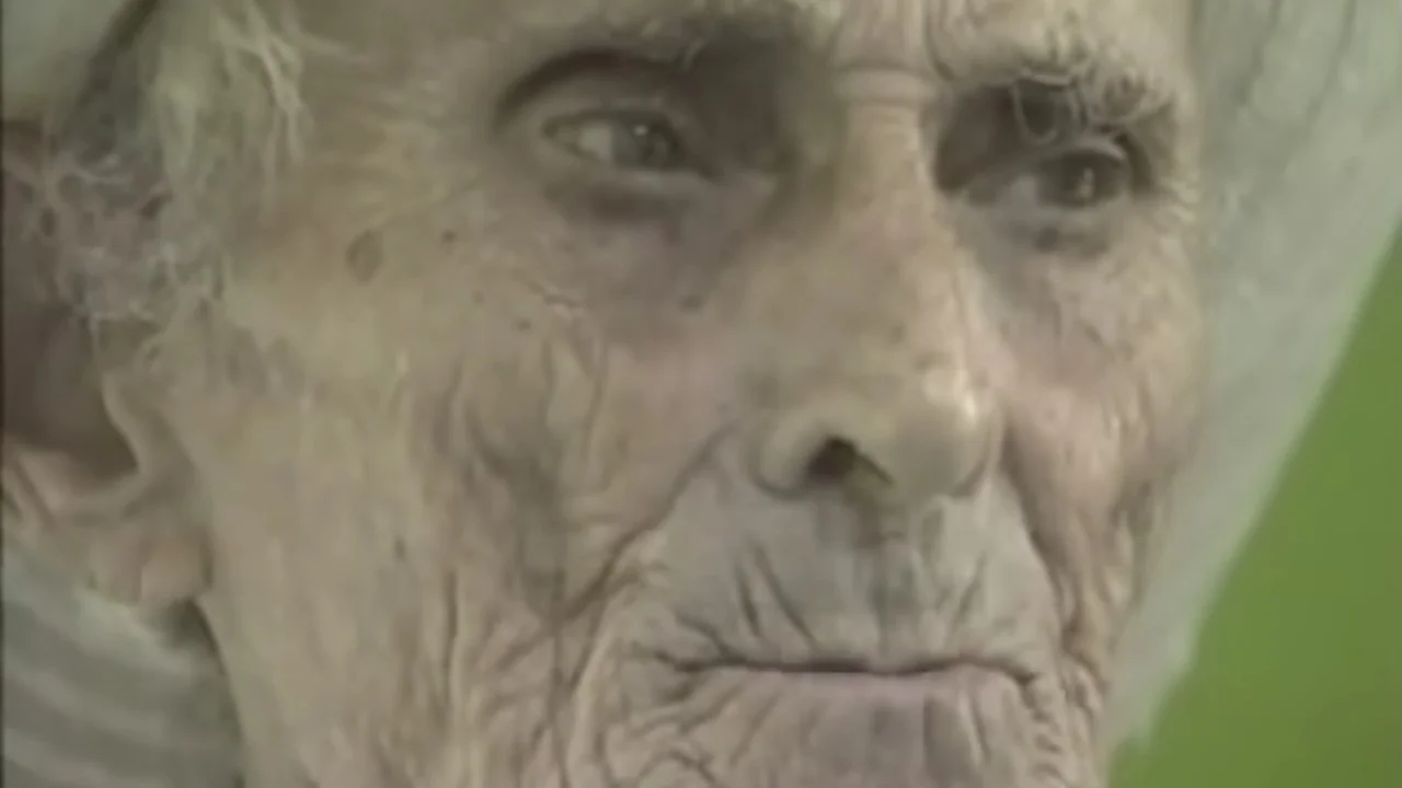 Extreme close-up of Nimrod Workman's aged, wrinkled face wearing a white head wrap
