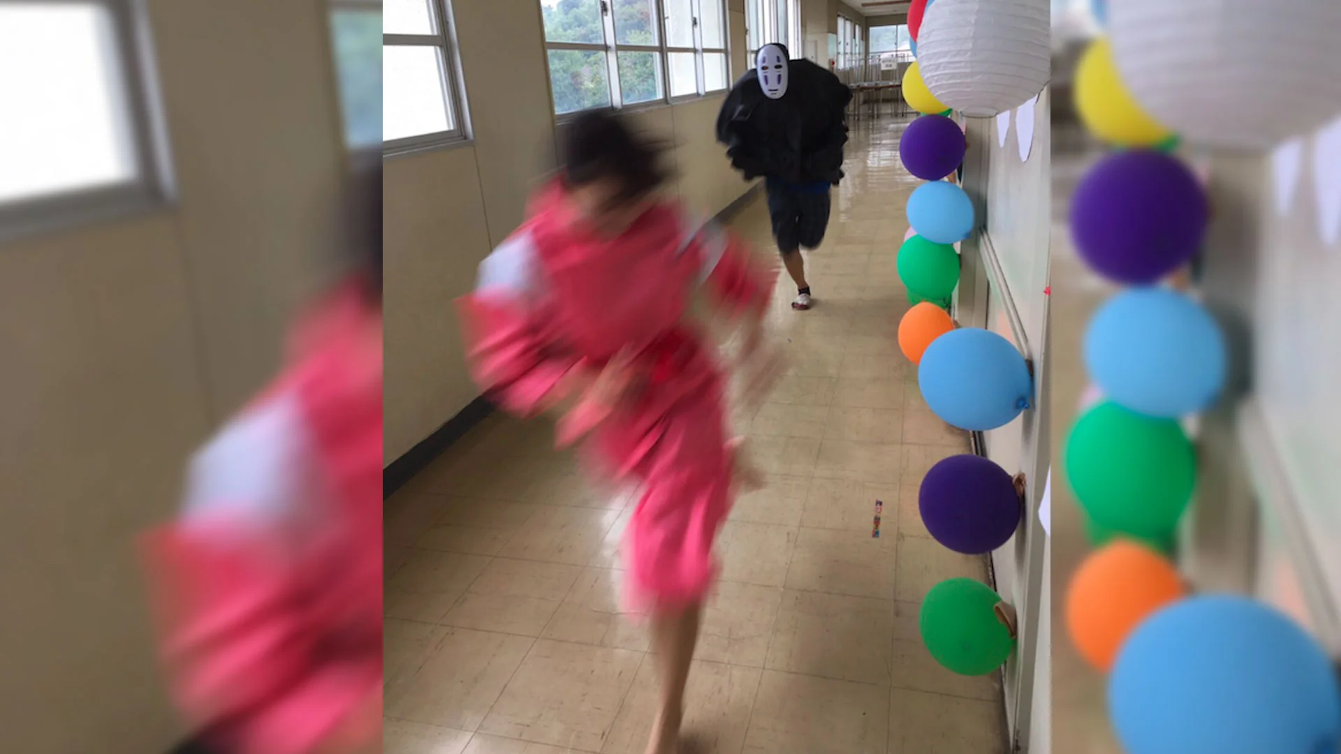 No Face Chasing Chihiro — Person in pink kimono running through balloon-decorated hallway from person in black cloak and No-Face mask