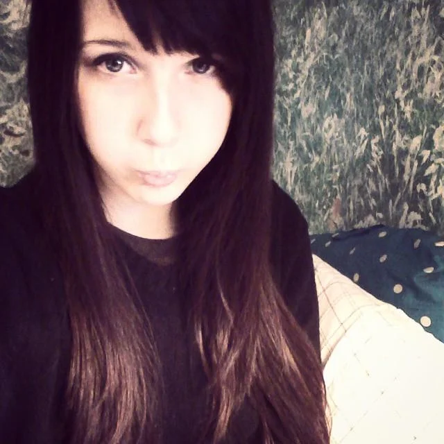 Old selfie of Nyanners as a young woman with long dark hair and bangs making a pouty face.