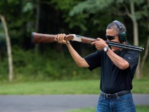 Obama Skeet Shooting Photo — President Obama in side profile firing shotgun at Camp David with ear protection and sunglasses.