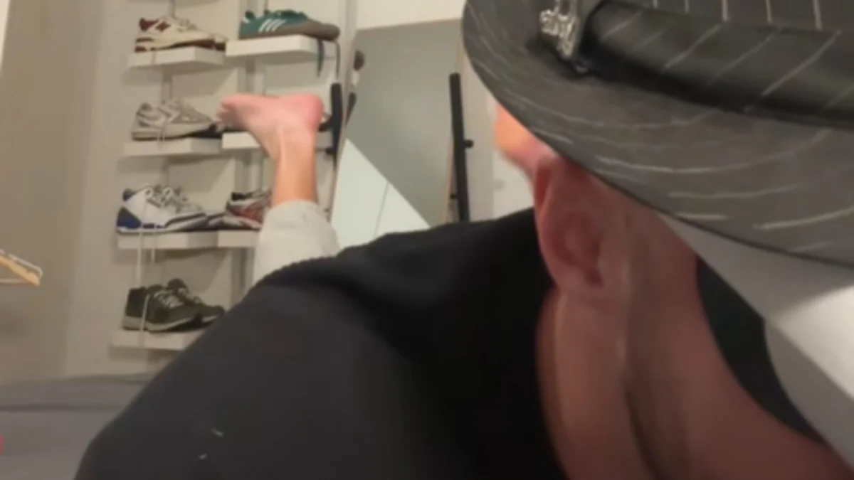 Oh Princess Where Are You — Close-up video still of a person in a backward cap with a bare foot pointing toward a sneaker shelf