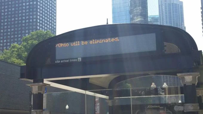 Ohio Memes — Dark building facade with glowing orange text projecting '/Ohio will be eliminated.'