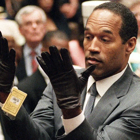 O.J. Simpson Murder Trial — O.J. Simpson raising black leather gloves in the courtroom during his murder trial