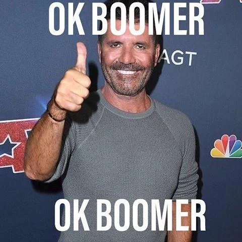 Man giving thumbs-up at public event with OK BOOMER text overlay.