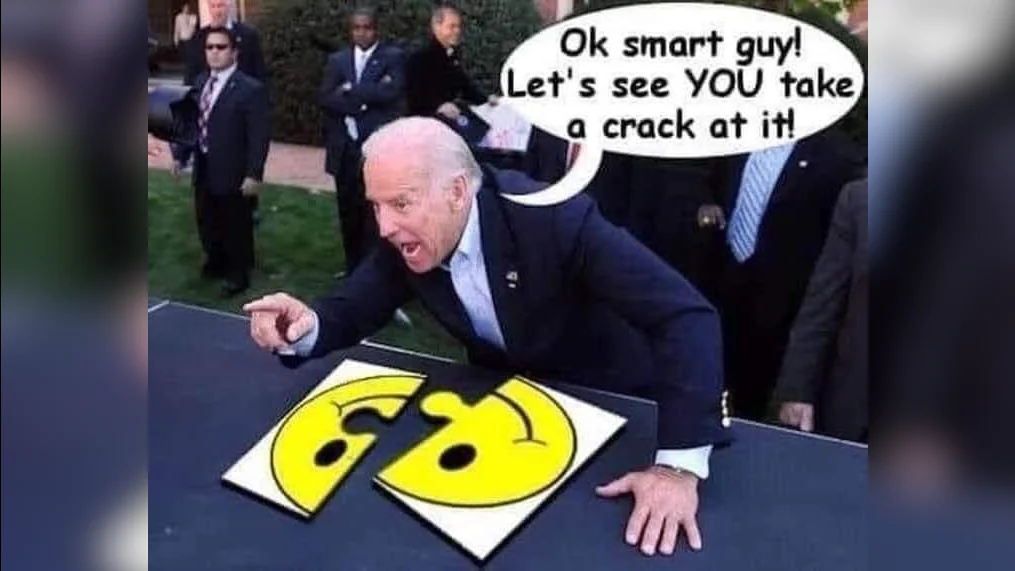 Joe Biden pointing at a torn smiley face puzzle with speech bubble reading 'Ok smart guy! Let's see YOU take a crack at it!'