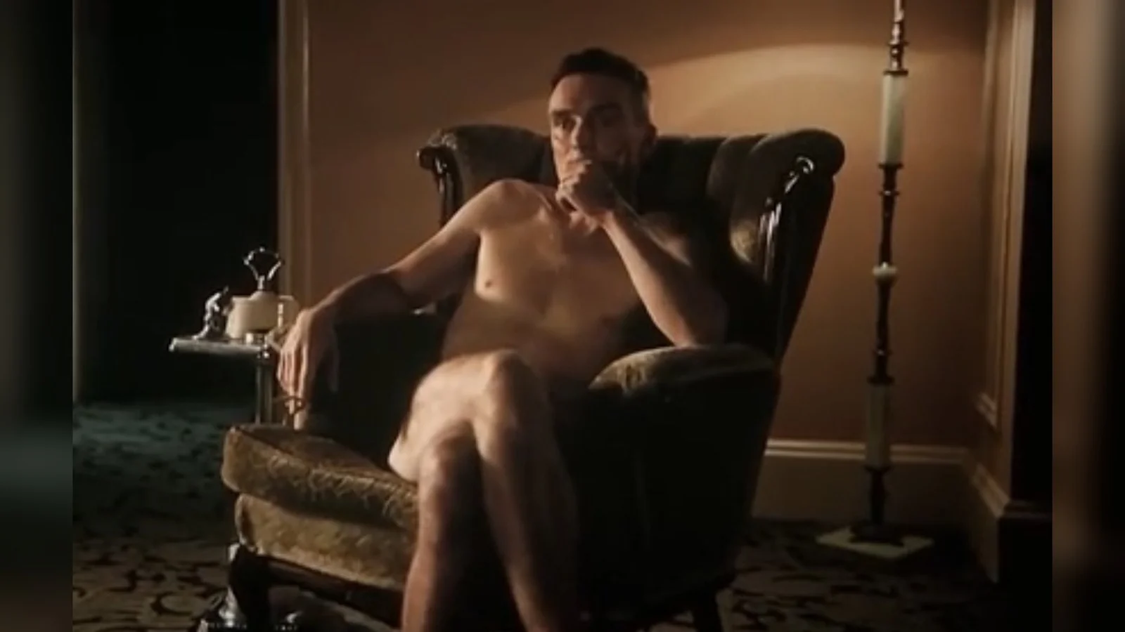 Oppenheimer Memes — Cinematic still of Oppenheimer character seated in leather chair contemplatively.