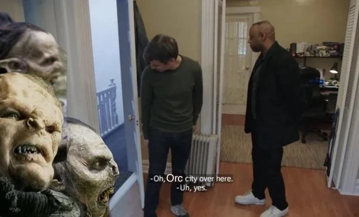Video scene with orc statue props and subtitle 'Oh, Orc city over here. Yes.'
