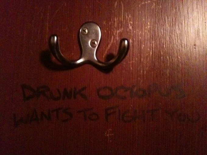 Pareidolia — Coat hook resembling an octopus with 'drunk octopus wants to fight you' graffiti