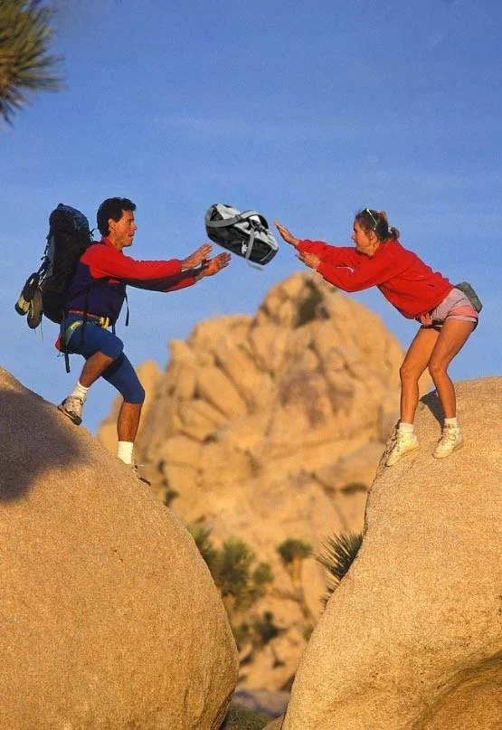 Parents Throwing Baby — Parents on rocks throwing a fanny pack in place of the baby