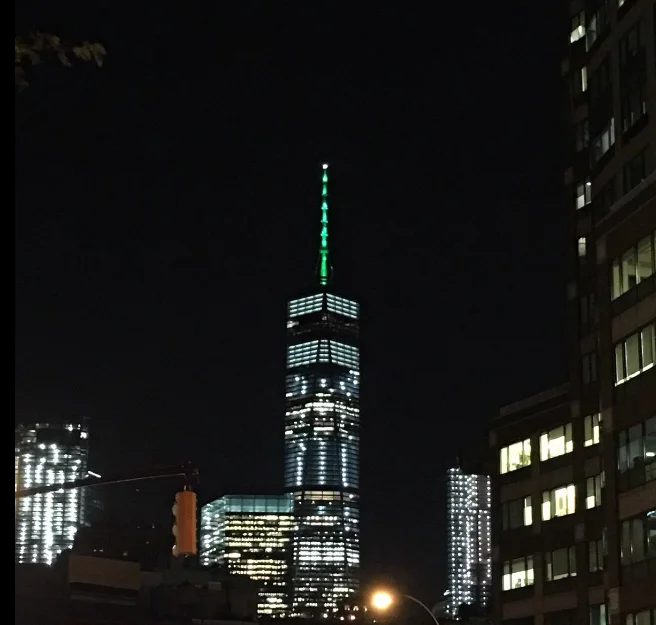 Paris Climate Agreement Withdrawal — One World Trade Center spire lit up green at night in protest of Paris Agreement withdrawal