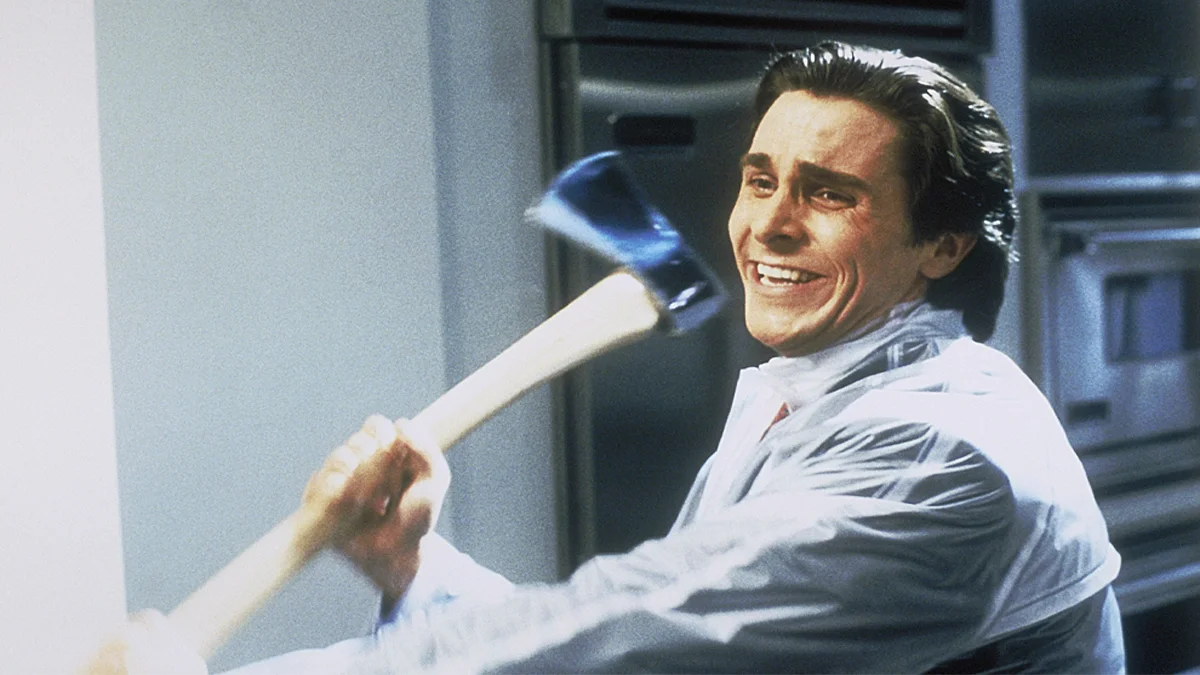 Patrick Bateman with An Axe — Christian Bale as Patrick Bateman grinning while wielding an axe