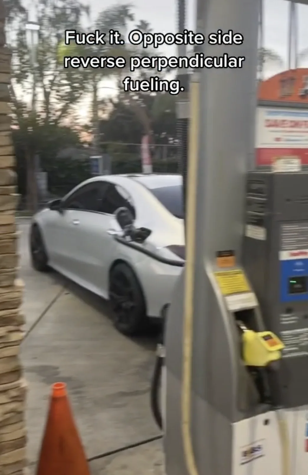 White Mercedes at a gas pump with the fuel hose draped across the car and text about opposite-side reverse perpendicular fueling.
