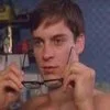 Peter Parkers Glasses — Tobey Maguire as Peter Parker from the 2002 Spider-Man film, shirtless and holding his glasses up to his face in a quizzical expression.