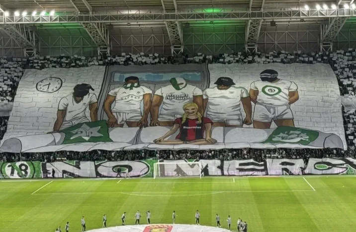Enormous stadium tifo banner depicting the Piper Perri Surrounded meme with football club jerseys added to the figures.