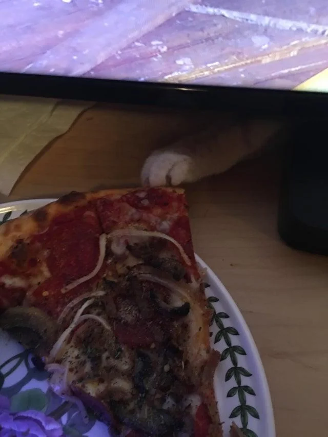 Pizza Crimes — A low-quality dimly-lit photograph of a pizza with some kind of marking or design drawn on top.
