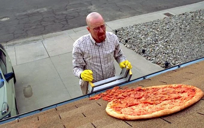 Pizza Crimes — A man in work clothes stands on a roof gutter handling a comically oversized pizza literally on a gutter pipe.
