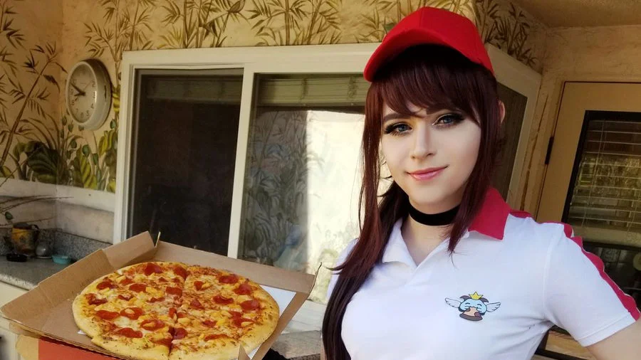 Pizza Delivery Sivir — Cosplayer in red cap and white pizza-delivery polo holding a pepperoni pizza