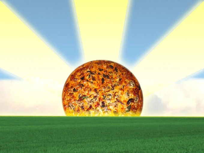 Pizza edited to look like a sun rising over green grass field