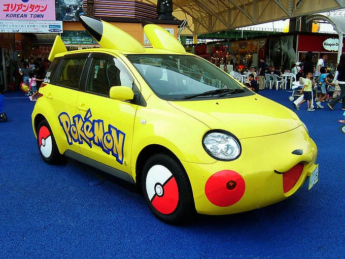 Pokémon — Woman in a yellow Pikachu costume holding a Pikachu plush