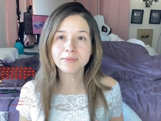 Pokimane No Makeup — Wider Twitch stream capture of Pokimane without makeup in a white lace top