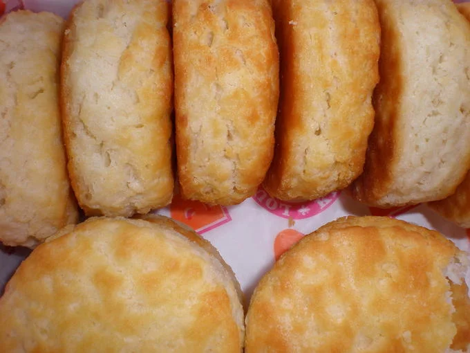 Close-up of golden-brown Popeyes biscuits on branded wrapper