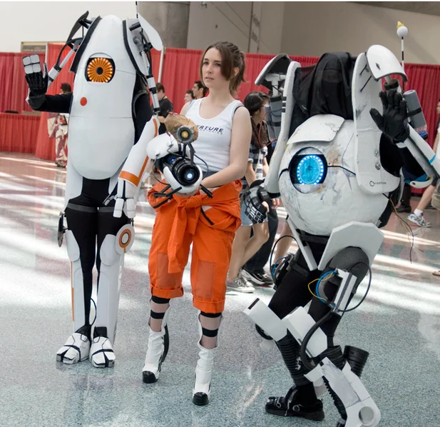 Convention cosplay of Chell with Atlas and P-Body robots from Portal