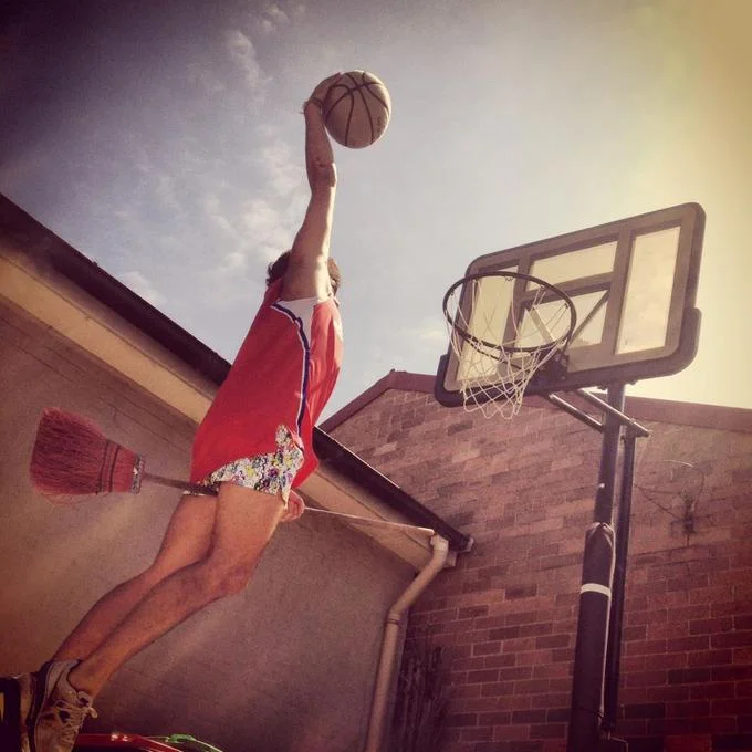 Person dunking a basketball while pottering on a broomstick