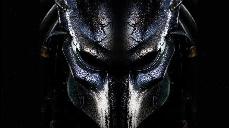 Close-up of the Predator's masked face against a dark background