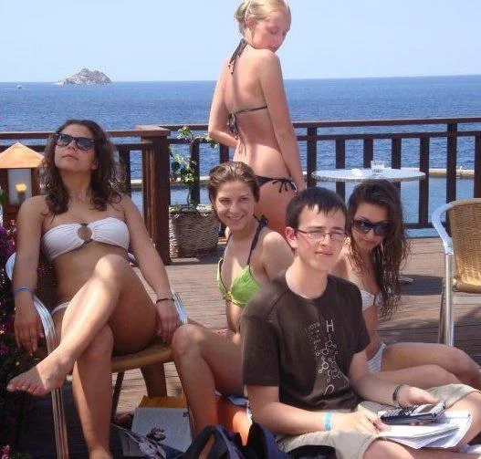 Uncaptioned source photograph of the Priority Peter meme showing a boy studying beside bikini-clad girls.