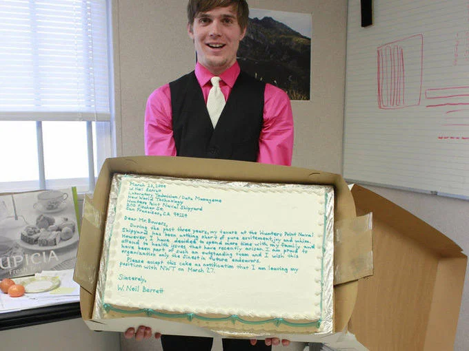 Public Resignation — Man holding a sheet cake with a resignation letter written in frosting