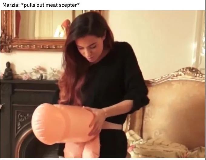 *Pulls Out Meat Scepter* — Marzia holding a large inflatable phallus with caption Marzia pulls out meat scepter