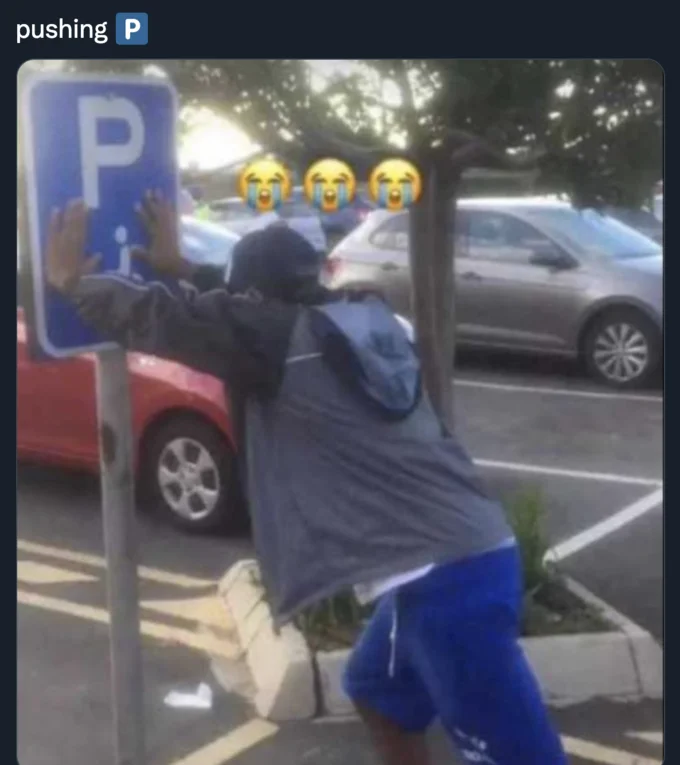 Pushin' P — Man literally pushing a parking P sign with pushing P caption