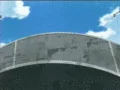 Quality — An anime still depicting a large curved concrete or metal surface against a bright sky with minimal detail and sparse composition.