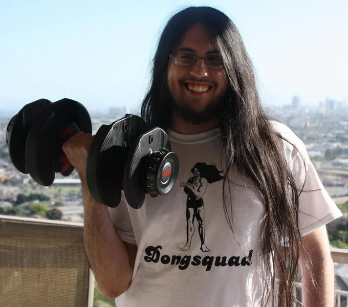 Raise Your Dongers — Man in Dongsquad t-shirt raising a dumbbell on a rooftop