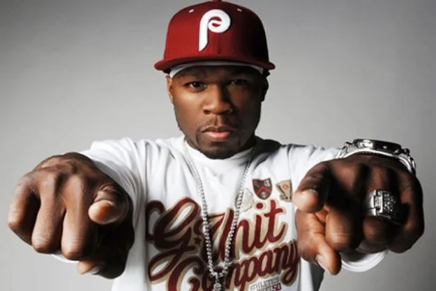 Rapper 50 Cent wearing a red Phillies cap and G-Unit Company shirt pointing at the camera
