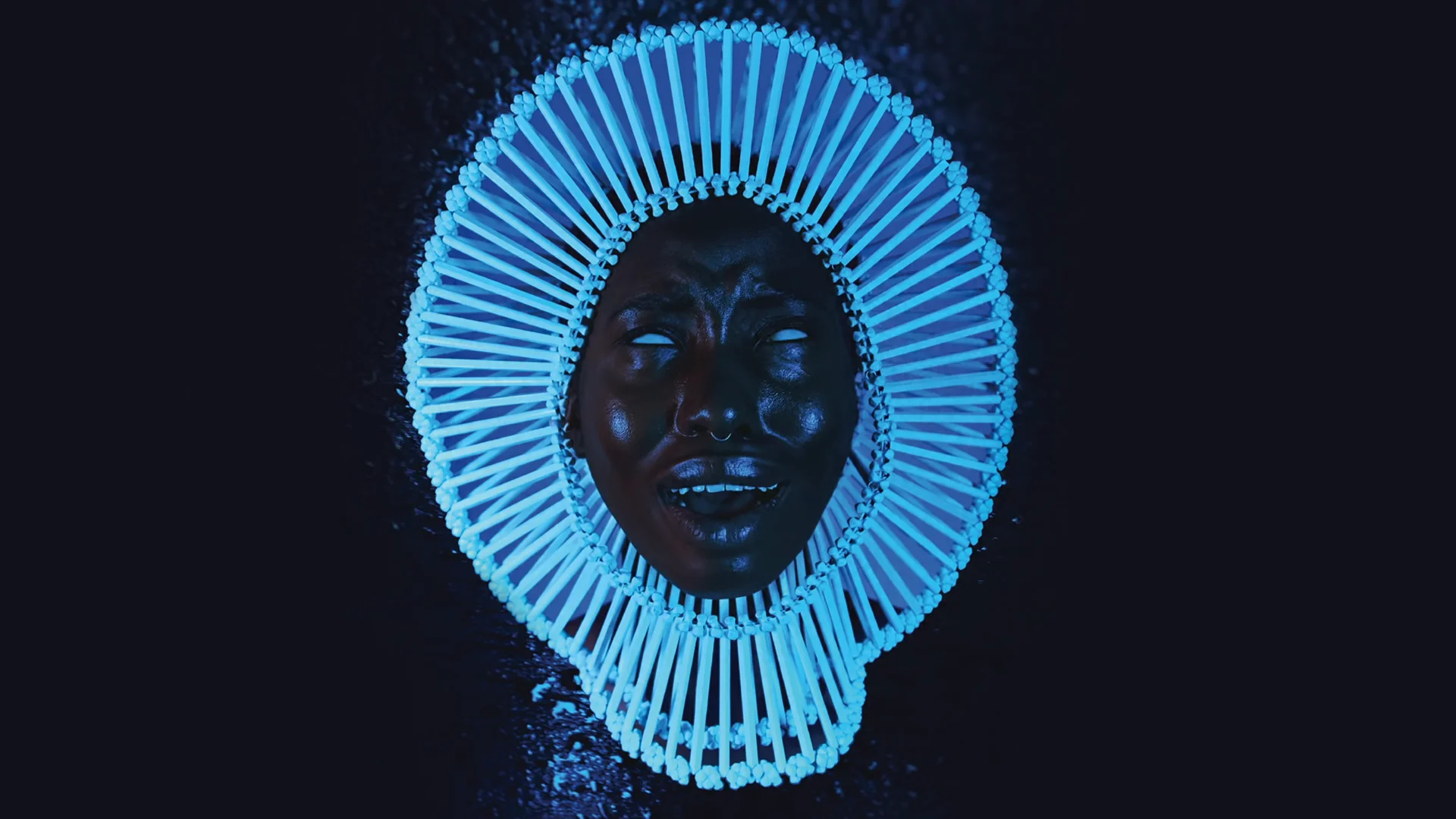 Screenshot from Childish Gambino's Redbone official audio video showing a face framed by a blue radial headdress on a dark background