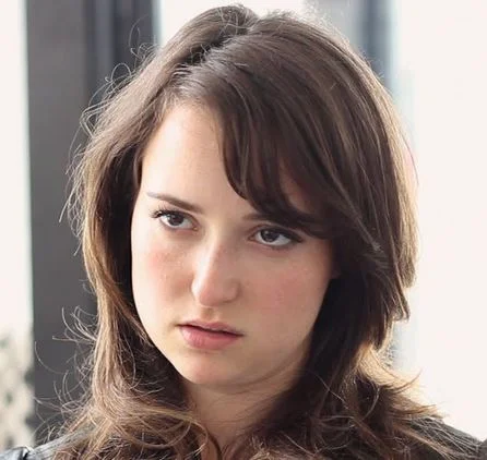 Resting Bitch Face — Young woman with long brown hair displaying a neutral, sullen facial expression