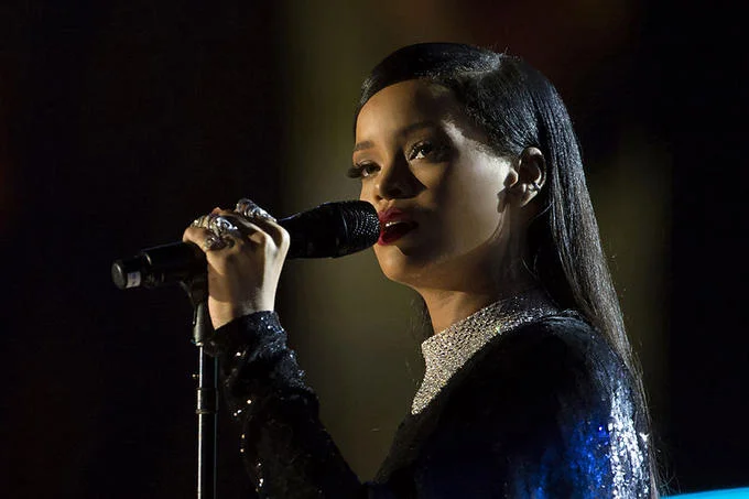 Rihanna singing into a microphone on stage