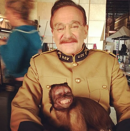 Robin Williams in Teddy Roosevelt costume holding a capuchin monkey on set of Night at the Museum
