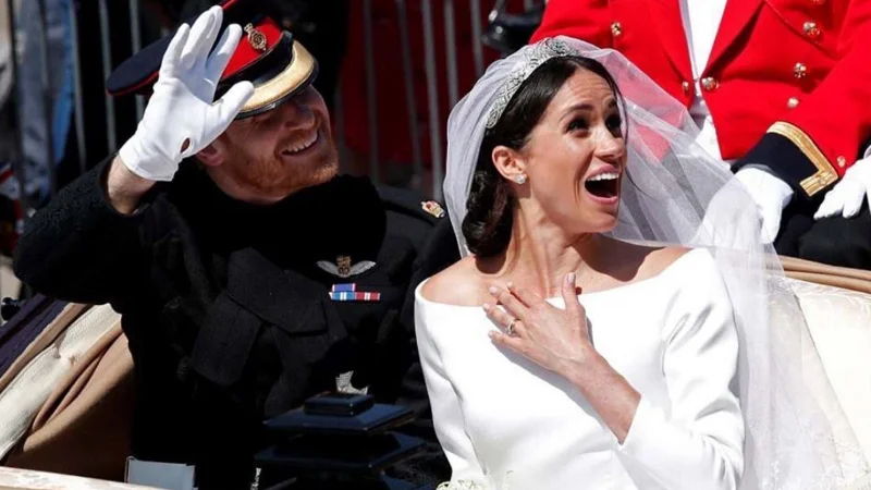 Royal Wedding of Prince Harry and Meghan Markle — Prince Harry saluting beside a smiling Meghan Markle in a wedding carriage.
