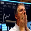 Sad Guys On Trading Floors — A male trader before stock exchange display board with DAX branding, hand raised to cover mouth in gesture of shock with wide-eyed