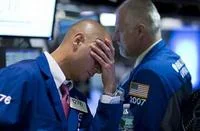 Sad Guys On Trading Floors — Two male traders on NYSE floor with man in foreground pressing hand hard against forehead in gesture of distress with busy