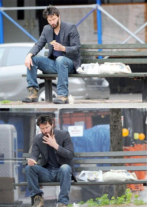 Sad Keanu — Two paparazzi photos of Keanu Reeves sitting alone on a park bench, eating and smoking.