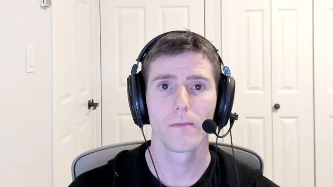 Sad Linus — A clean portrait of Linus Sebastian wearing gaming headphones with microphone boom in home studio with serious melancholic expression.