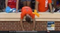Sad Virginia Fan hunched over stadium brick wall while hand holds orange pompom or towel nearby with Notre Dame 32 score visible.